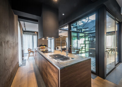 Modern industrial kitchen design with a concrete wall and a wall of windows.